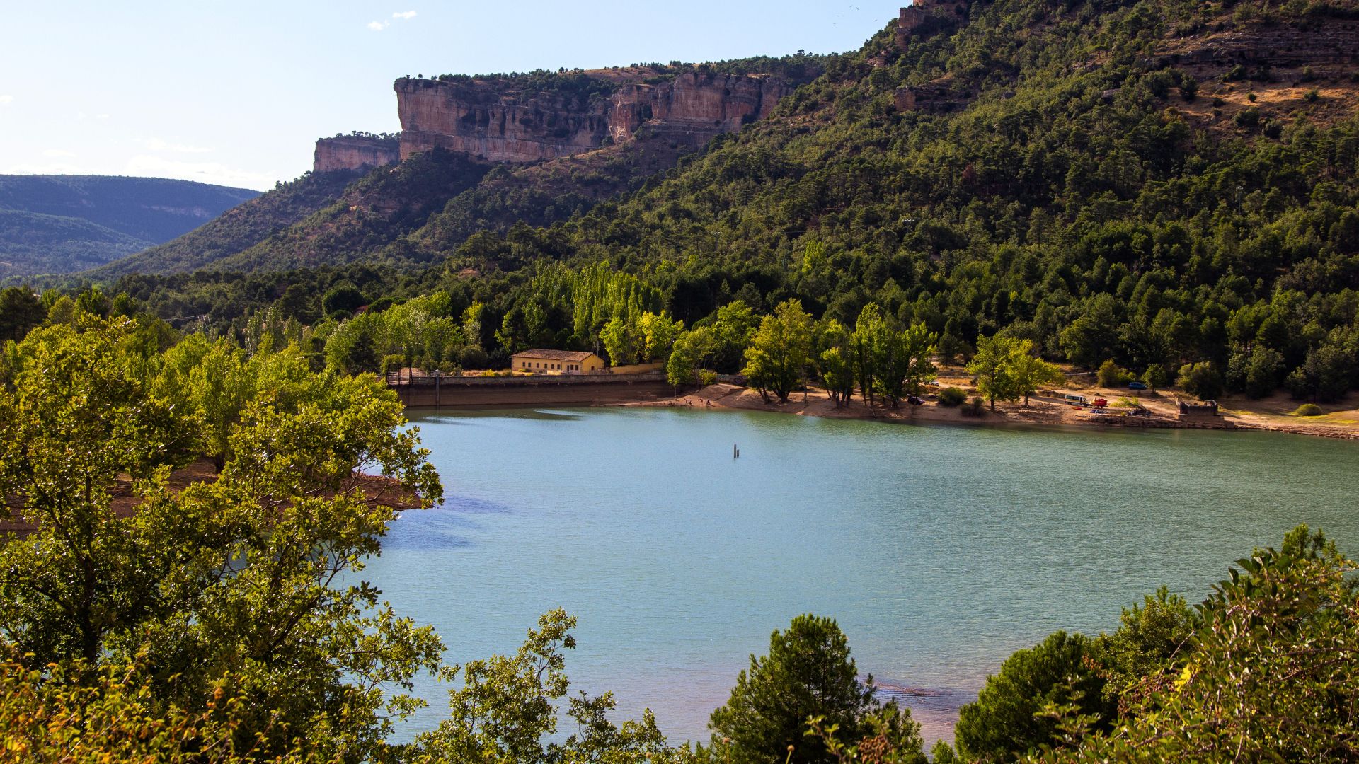 A lake nestled between trees and mountains