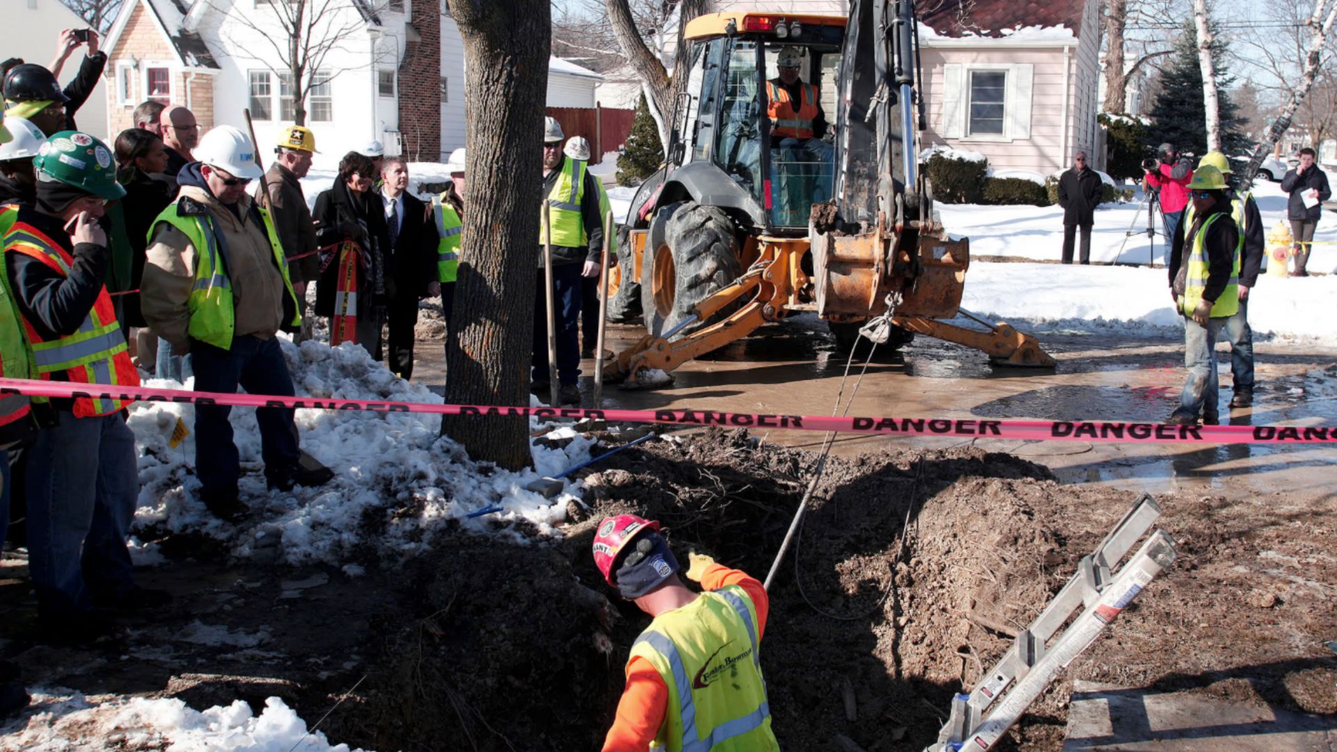 Workers prepare to replace a lead water service line at the site of the first Flint home with high lead levels