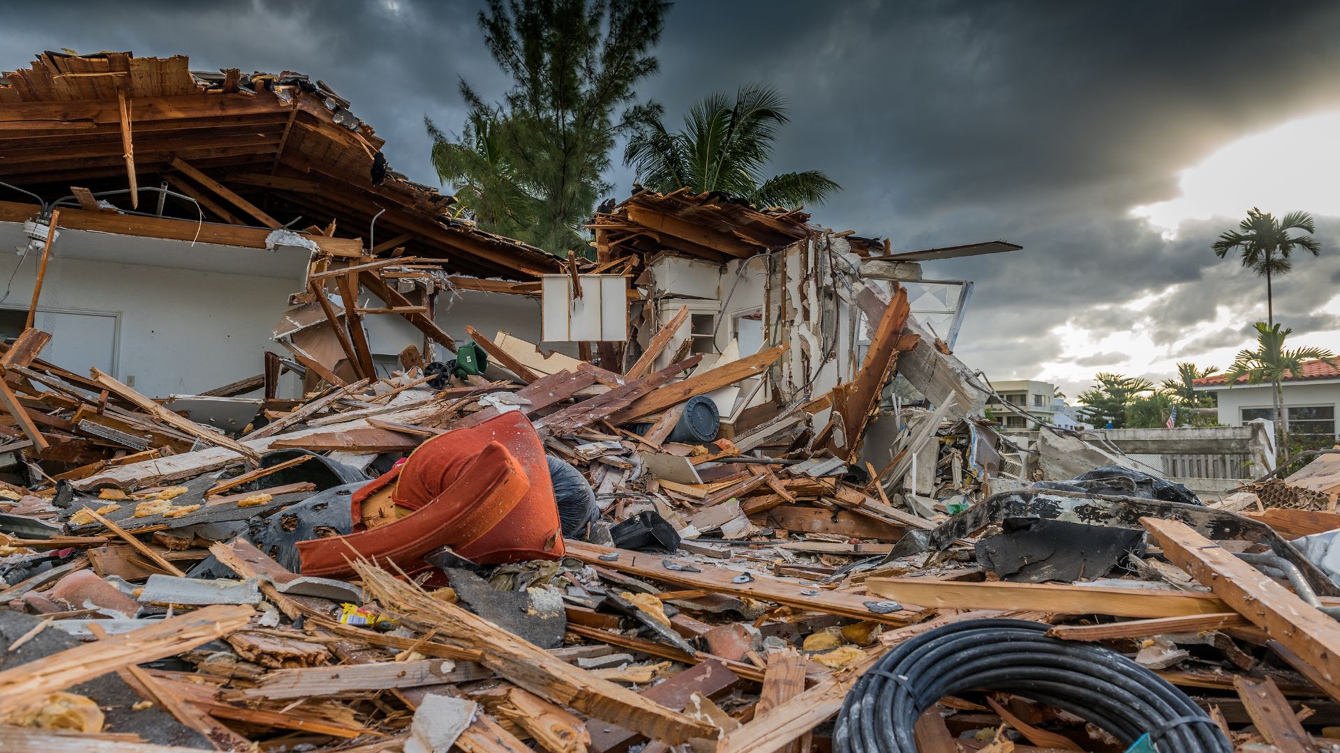 Casa colapsada con graves daños estructurales y escombros esparcidos alrededor, ilustrando la destrucción causada por un huracán reciente.