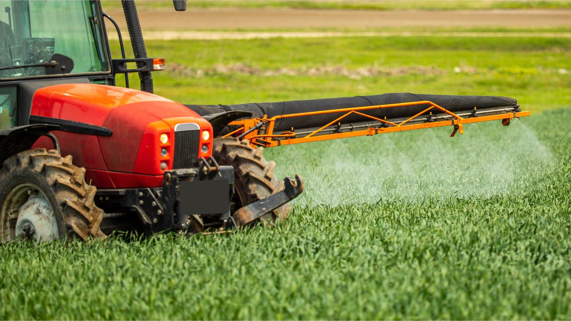 Herbicidas, pesticidas y fungicidas aplicados por tractor en campos de trigo.